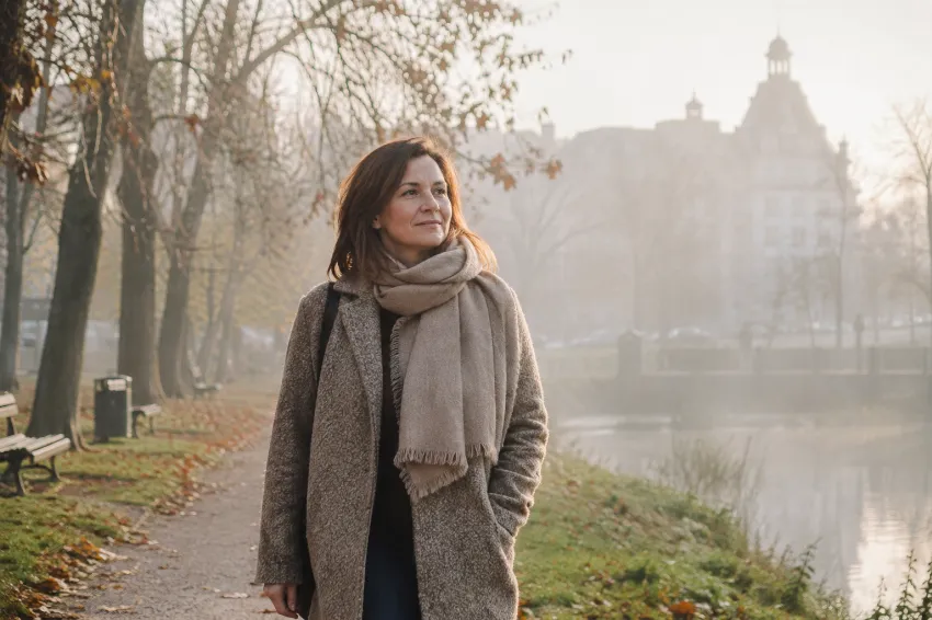 Ženska na jesenskem sprehodu pod šibkim soncem, ko koža ne tvori dovolj vitamina D
